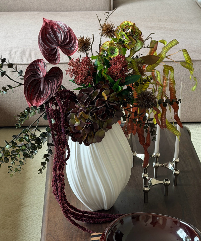 Kunstblumenstrauß Forest Ember in Bordeaux, Grün & Braun aus der Serie Bloom – auf dem Couchtisch im Wohnzimmer