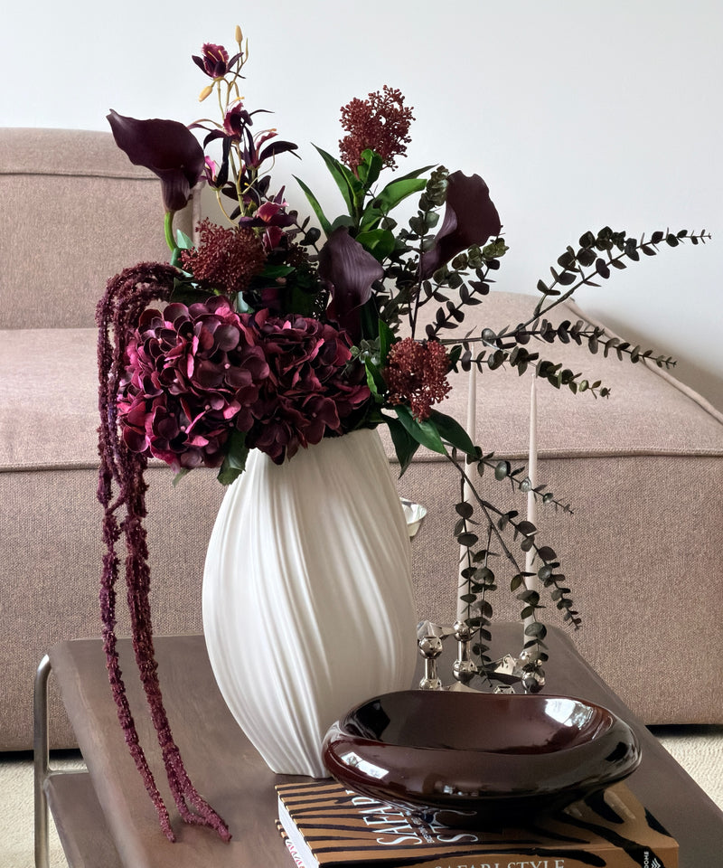 Kunstblumenstrauß Merlot Night in Bordeaux & Grün aus der Serie Bloom – auf dem Couchtisch im Wohnzimmer