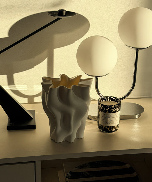 Cleo Keramikvase auf dem Sideboard neben Tischleuchte und Kerze im Sonnenlicht
