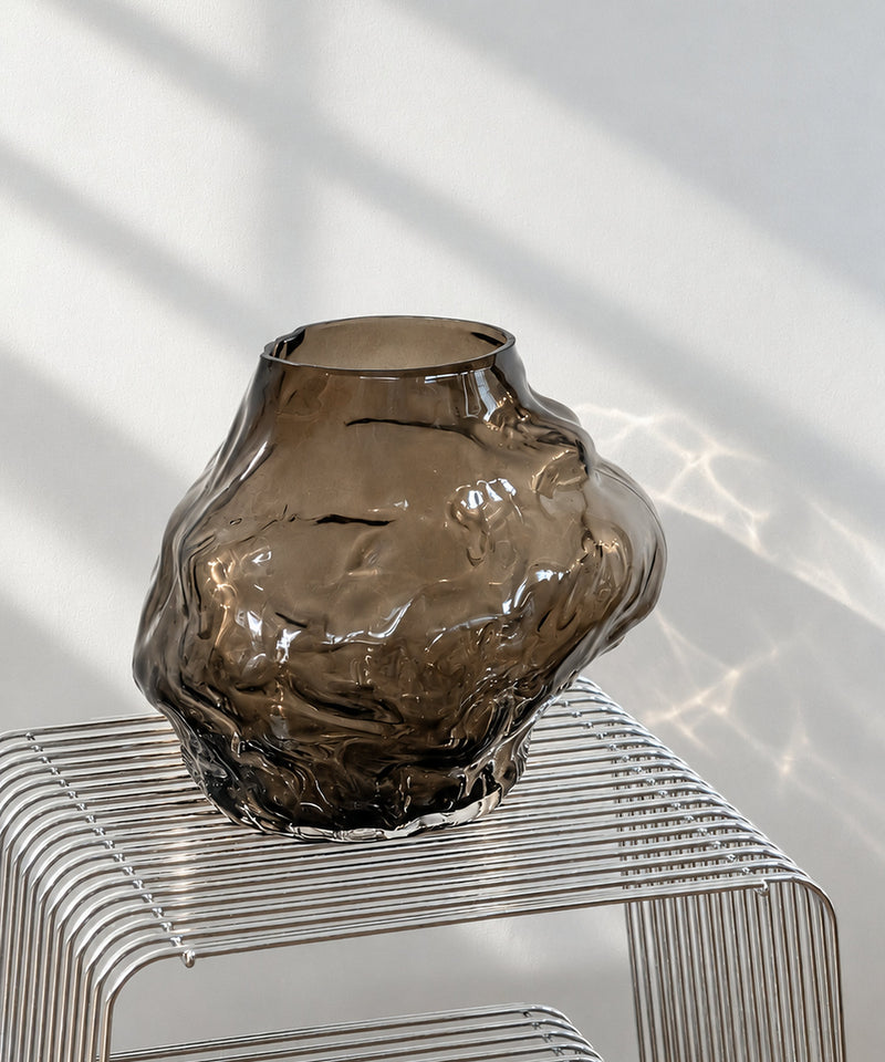 Suri Glasvase aus braunem Rauchglas auf einem Drahttisch im Tageslicht