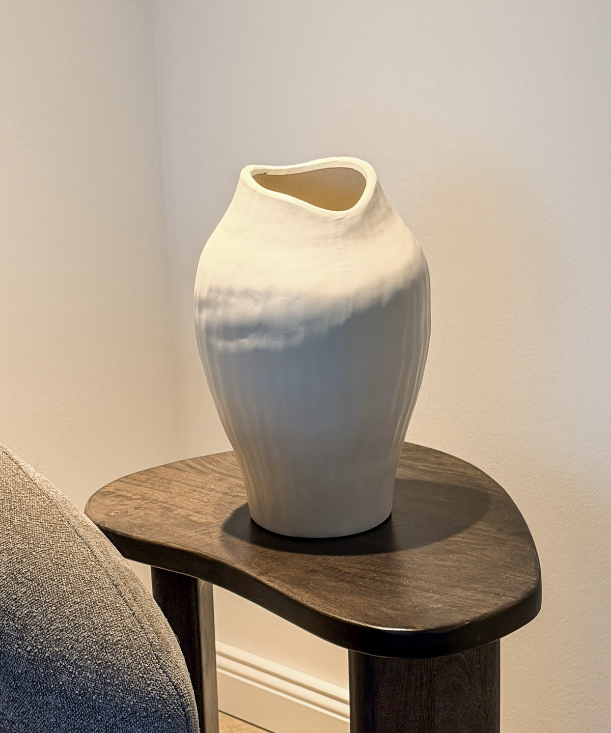 Große Maira Vase auf einem dunklen Beistelltisch neben dem Sessel